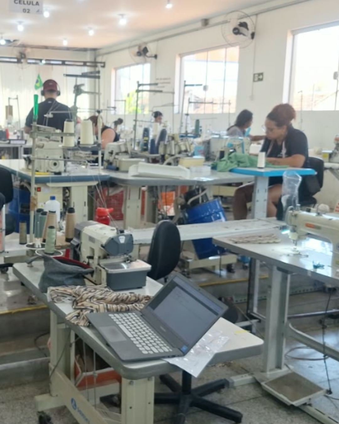 Área ampla de costura com máquinas industriais